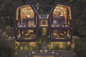 A modern residential building with glass facades, illuminated at night.