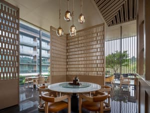 A modern restaurant interior features a combination of wood and glass materials.