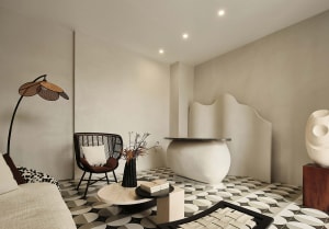A modern living room featuring a concrete fireplace and patterned tile floor.