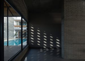 A minimalist interior featuring a brick and concrete art installation.