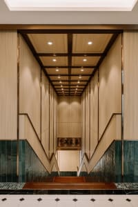 An elegant, tall staircase with wooden panels and marble flooring leading upwards.