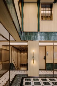 A modern lobby featuring marble walls and monochrome flooring.