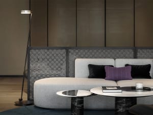 A modern living room featuring a grey sofa, marble center table, and grey floor lamp.