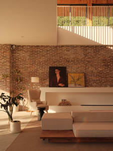 Industrial living room featuring a brick wall and concrete floor.