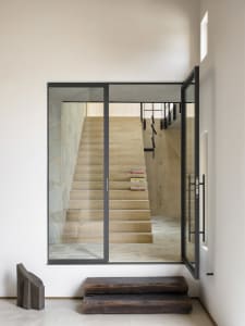 Modern interior with concrete staircase and large glass windows.