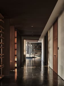 Modern, minimalist corridor with dark wood flooring and walls, showcasing a sleek and sophisticated design.