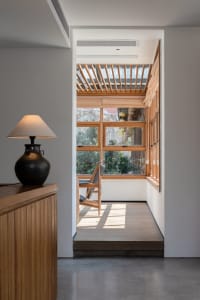 Modern interior space featuring wooden window view and minimalist design elements.