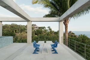 Minimalist patio featuring modern concrete and metal seating and table.