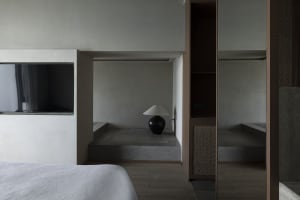 Minimalist bedroom with concrete floor and wood accents