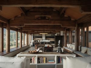 Minimalist living room with wooden beams, a white bookshelf, and a sofa.