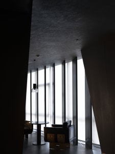 A modern lobby space featuring glass and concrete materials.