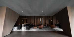 Industrial-style retail lobby with wooden walls and black and brown furniture.