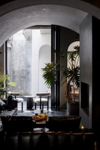 A modern restaurant lounge with concrete, leather, and glass materials.