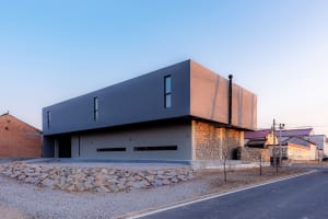A sleek, modern building exterior in concrete and metal with a unique design