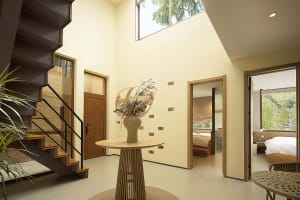 A modern interior space featuring a metallic staircase, natural light, and minimalist design.