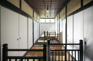 Modern wooden staircase with white walls and wooden railings.