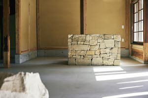 a room with a stone wall and wooden paneling, showcasing modern interior design elements