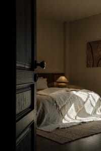 Bedroom with a minimalist design featuring a wool blanket on the bed.