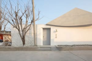 A minimalist entryway featuring a concrete door and wall with a sleek, modern design.