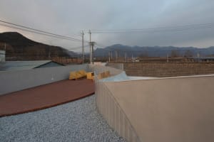Modern outdoor space featuring brick patio and gravel surround
