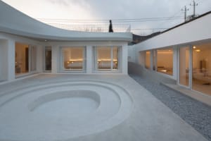A modern residential interior featuring a circular concrete courtyard with large windows.