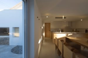 Modern white kitchen featuring a wooden countertop and contemporary design elements.