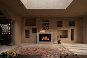 Minimalist living room with a concrete floor, fireplace, and built-in shelves.