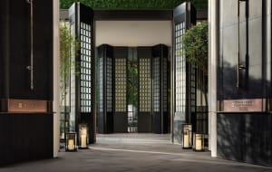 Modern hotel entryway featuring black glass and wooden panels