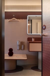 A minimalist bathroom featuring a terrazzo countertop, fabric accents, and wooden elements.