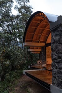 Modern outdoor living space featuring wooden construction and stone columns.