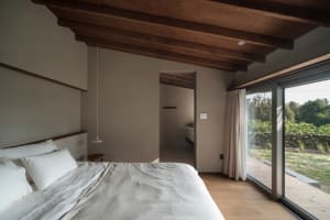 A minimalist bedroom with wooden walls and a bed with a wooden headboard.