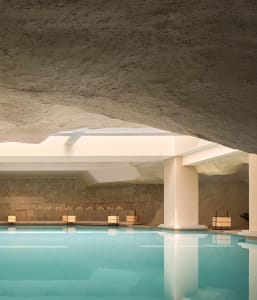 Swimming pool interior with a modern design featuring concrete walls and ceiling.