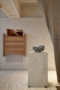 A modern interior design featuring ceramic art on a contemporary pedestal.
