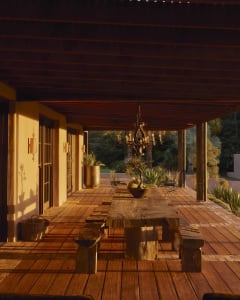 A cozy wooden patio featuring rustic furniture and greenery.