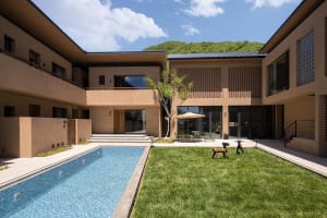 Modern residential backyard house with concrete, bamboo, and glass materials.