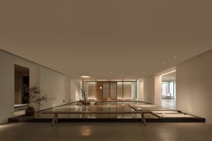 Modern hotel lobby featuring a concrete floor, minimalist design, and open space.