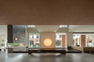 A minimalist living room with concrete flooring and minimalist furniture.