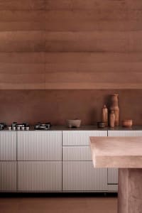 Modern residential kitchen featuring concrete cabinets with marble countertops and minimalist design.