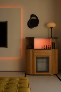 A modern living room featuring a wooden bar with orange backlighting.