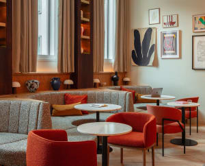 A modern cafe interior designed with fabric seating and marble tables.