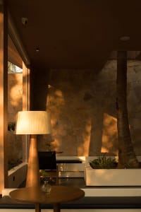 A modern interior design featuring a stone wall and a lamp.