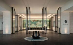 A modern hotel lobby featuring marble, glass, and metal materials