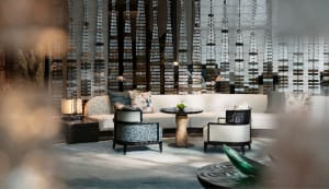 Modern lounge area with textured fabric seating, round tables, and decorative elements.