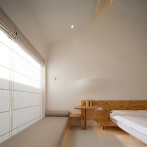 A minimalist bedroom featuring modern design elements and wooden furniture.