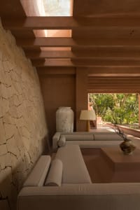Minimalist living room with concrete furniture and exposed beams
