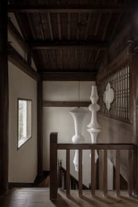 Modern staircase with white pendant lights and wooden railings in an interior setting.