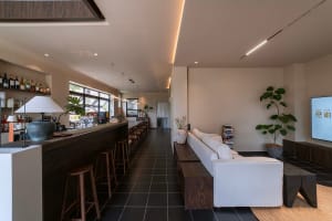 A modern coffee shop featuring wooden furniture, concrete walls, and glass elements.