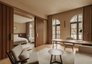 A modern, minimalist residential interior with wooden furniture and glass windows.