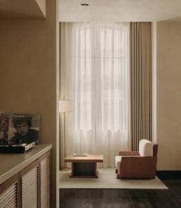 A modern living room featuring neutral-colored furniture and decor.