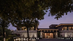 Modern residential exterior featuring concrete, glass, and wood materials.